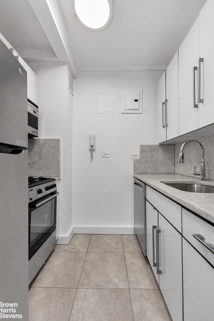 750 Park Avenue, Unit 3B Manhattan, NY 10021 - Photo 6 of 13 a kitchen with granite countertop a sink stove and cabinets