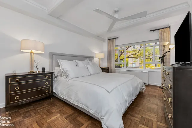 a bedroom with a bed and a flat tv screen on a dresser