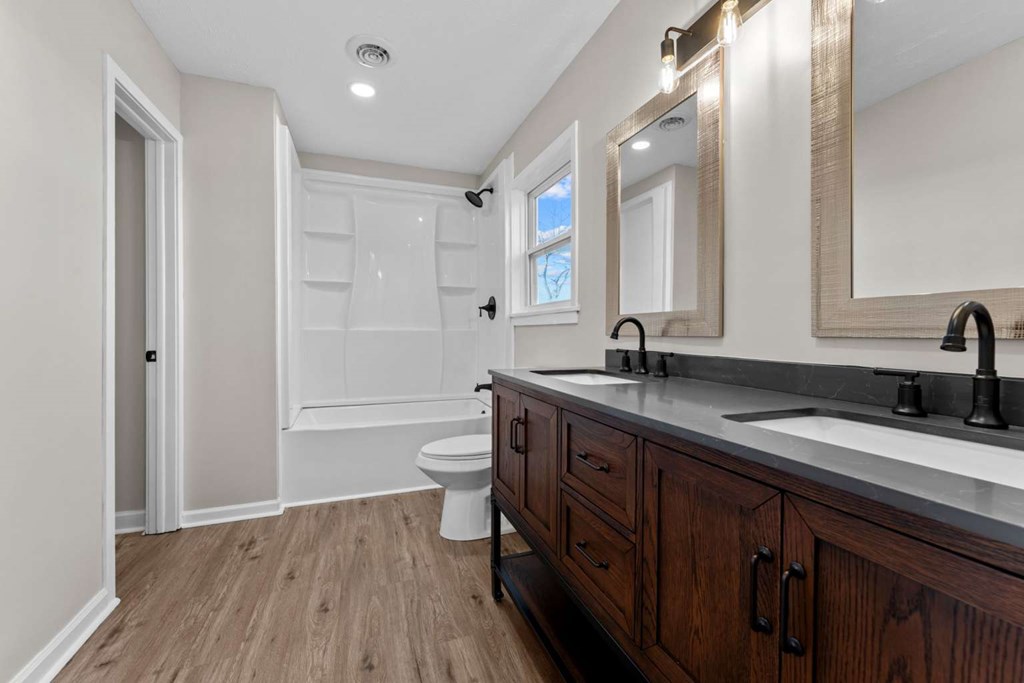 195 Hogsed Road Hiawassee, GA 30546 - Photo 9 of 25 a spacious bathroom with a granite countertop sink a toilet and a mirror