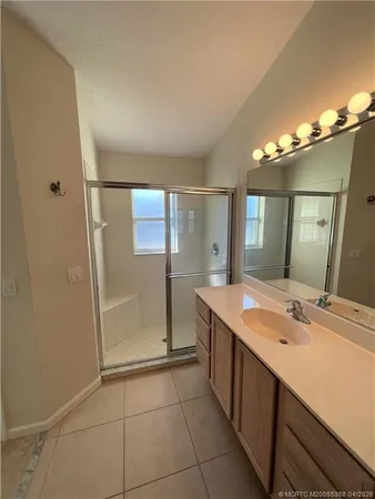 a bathroom with a double vanity sink a mirror and a shower