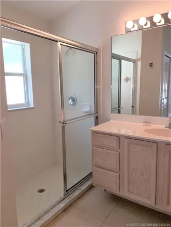 a bathroom with a shower sink and mirror