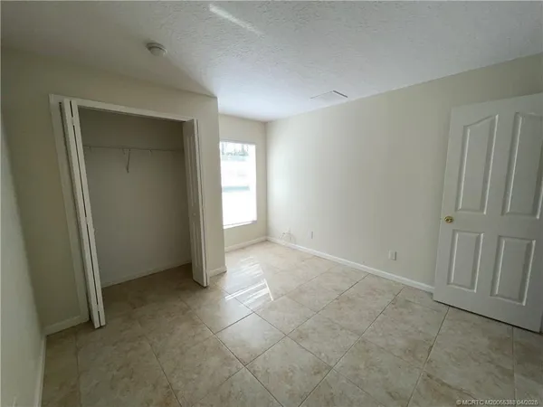 an empty room with windows and closet