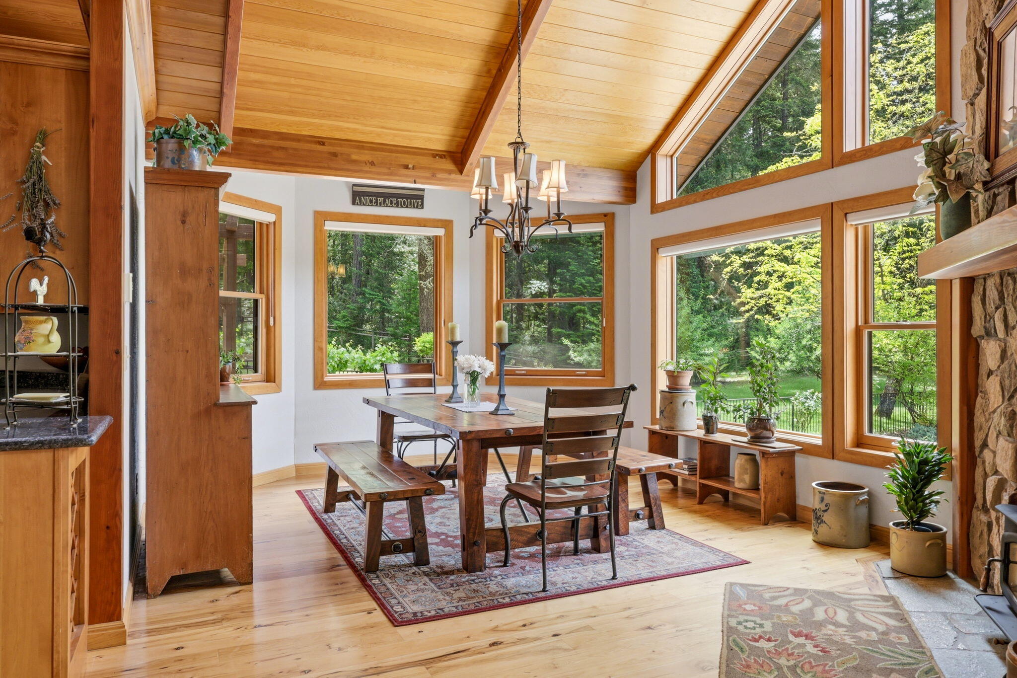 985 Elliott Creek Road Wilderville, OR 97543 - Photo 11 of 98 a view of a dining room with furniture large windows and wooden floor