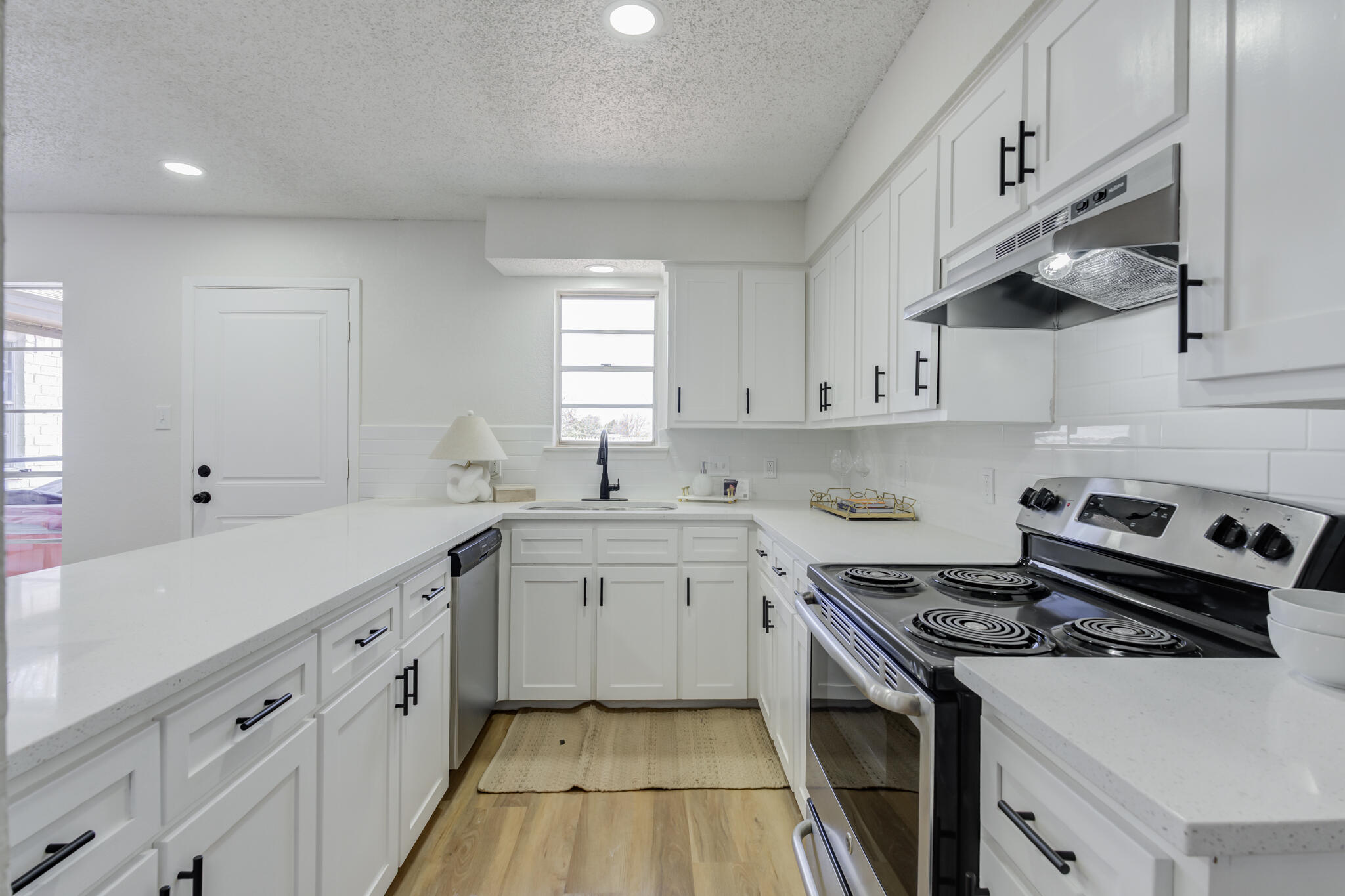 2314 77th Street Lubbock, TX 79423 - Photo 15 of 41 a kitchen with cabinets appliances a sink and a window