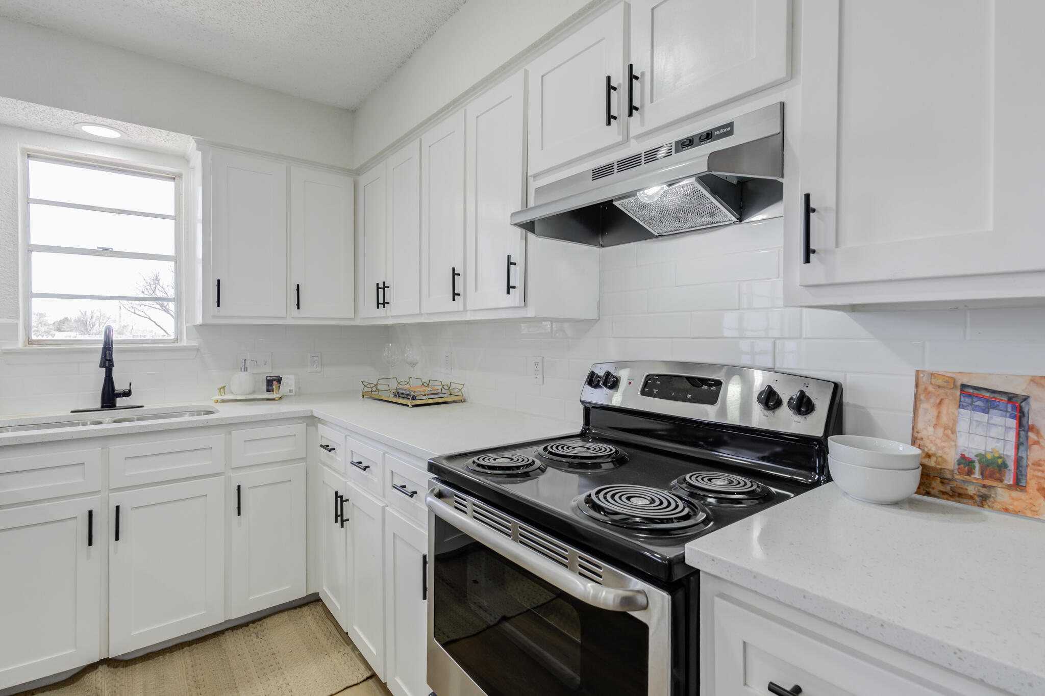 2314 77th Street Lubbock, TX 79423 - Photo 16 of 41 a kitchen with cabinets appliances a sink and a window