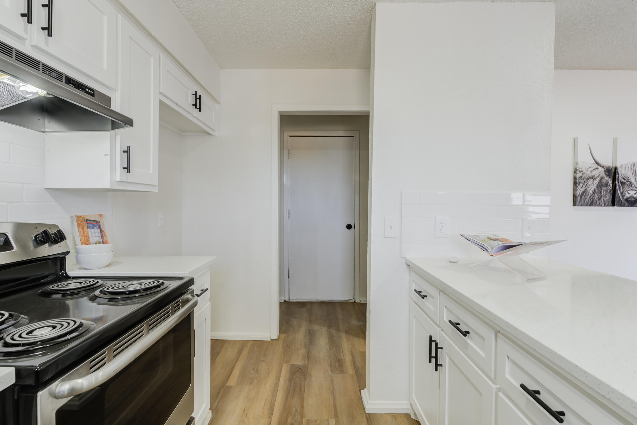 2314 77th Street Lubbock, TX 79423 - Photo 19 of 41 a kitchen with a stove and a wooden floor
