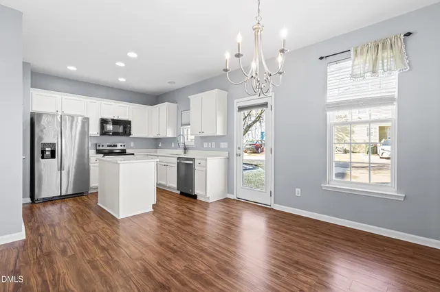 a view of kitchen with granite countertop stainless steel appliances cabinets and wooden floor