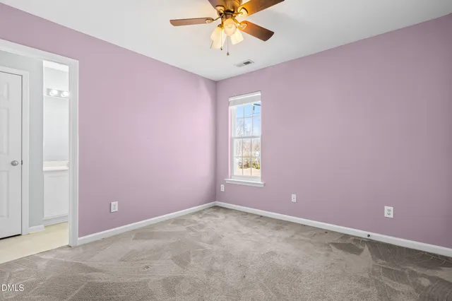 an empty room with a window and a fan