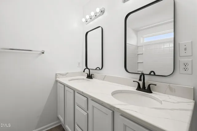 a bathroom with a double vanity sink and a mirror