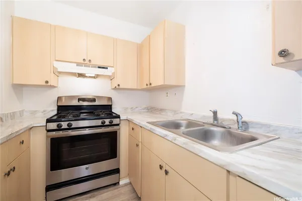 a kitchen with cabinets appliances a sink and a counter top
