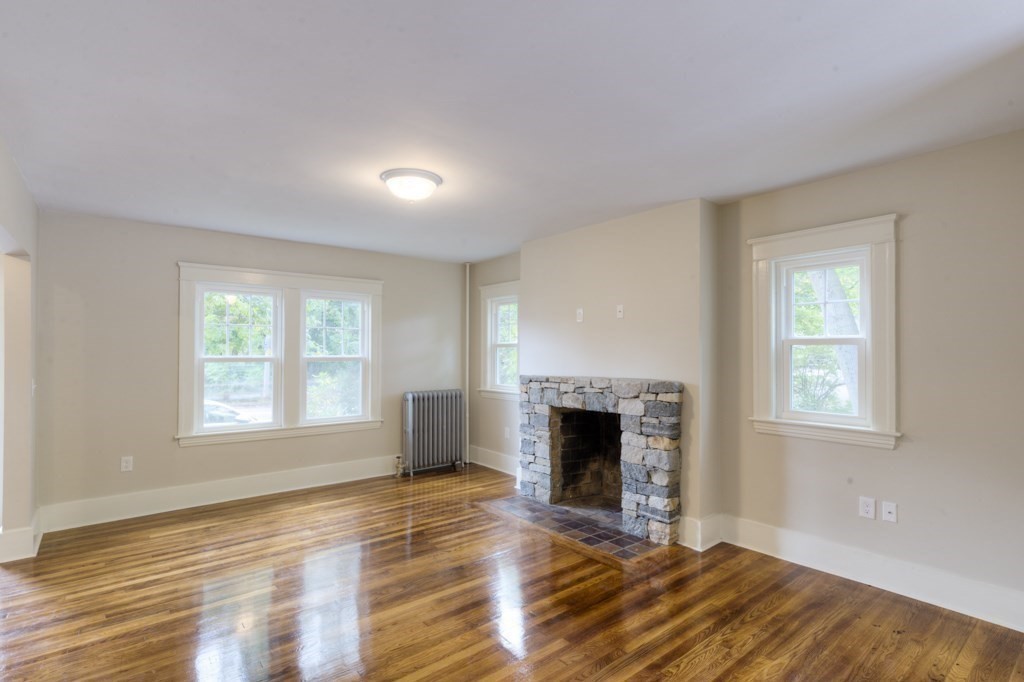 50 Mower Street Worcester, MA 01602 - Photo 4 of 38 an empty room with windows a fireplace and wooden floor
