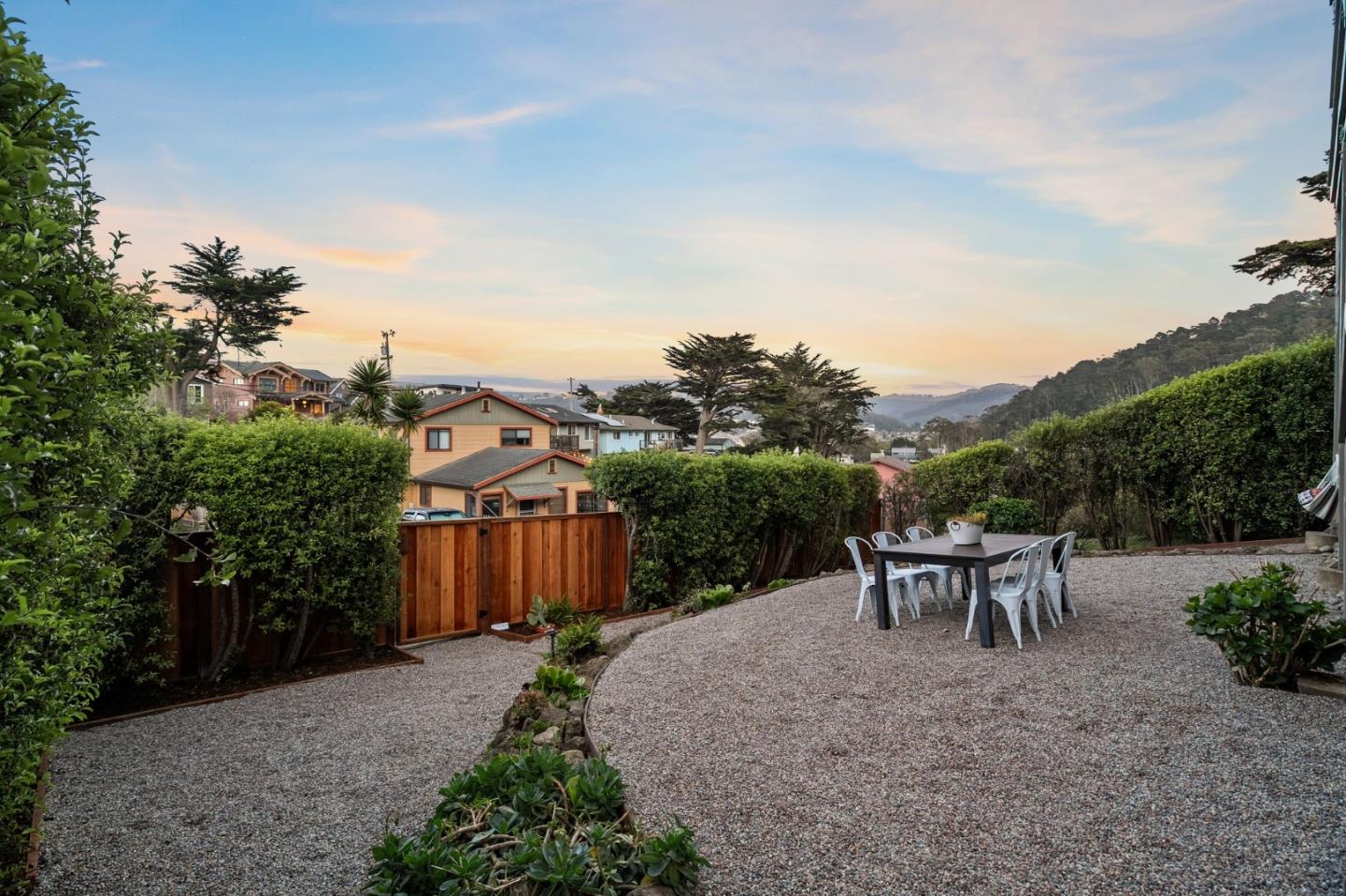 115 Stanley Avenue Pacifica, CA 94044 - Photo 55 of 61 a view of a patio with table and chairs and potted plants with wooden fence