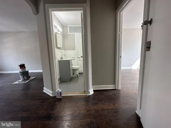 a view of a livingroom with wooden floor and a bathroom