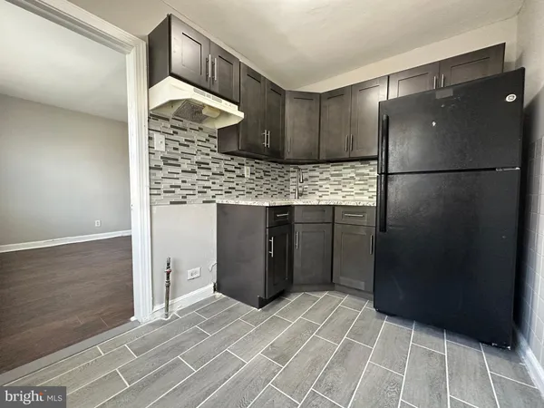 a kitchen with stainless steel appliances kitchen island granite countertop a refrigerator and a sink
