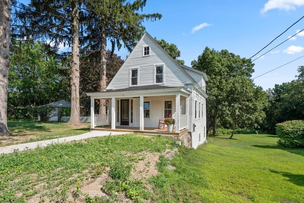 337 Boston Road Sutton, MA 01590 - Photo 3 of 38 a front view of a house with a yard table and chairs