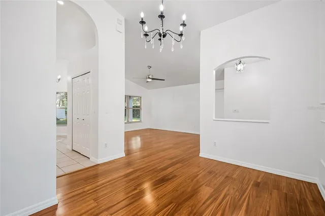wooden floor in an empty room with a chandelier