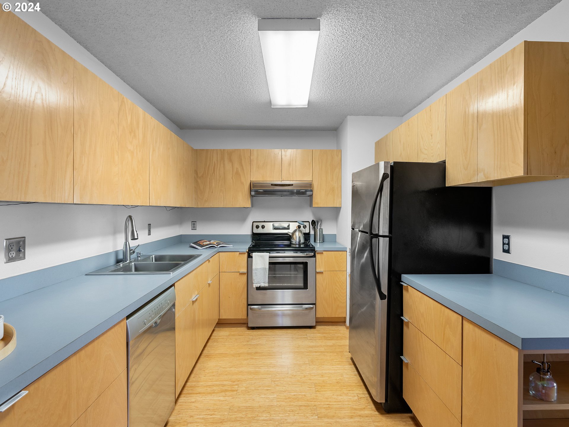 1727 Northeast Multnomah Street, Unit 14 Portland, OR 97232 - Photo 11 of 31 a kitchen with stainless steel appliances a stove a sink and a microwave