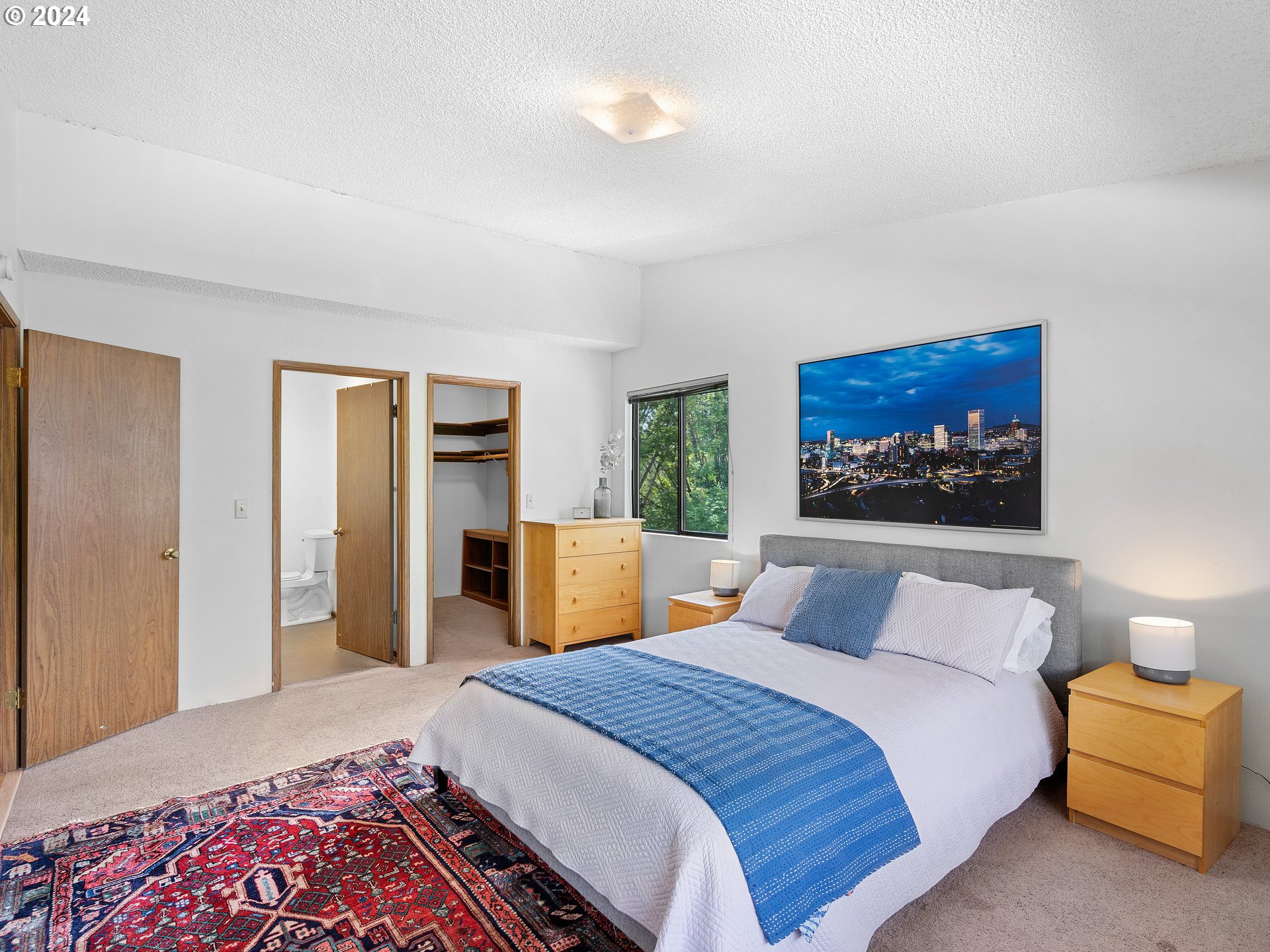 1727 Northeast Multnomah Street, Unit 14 Portland, OR 97232 - Photo 17 of 31 a bedroom with a large bed and a chandelier