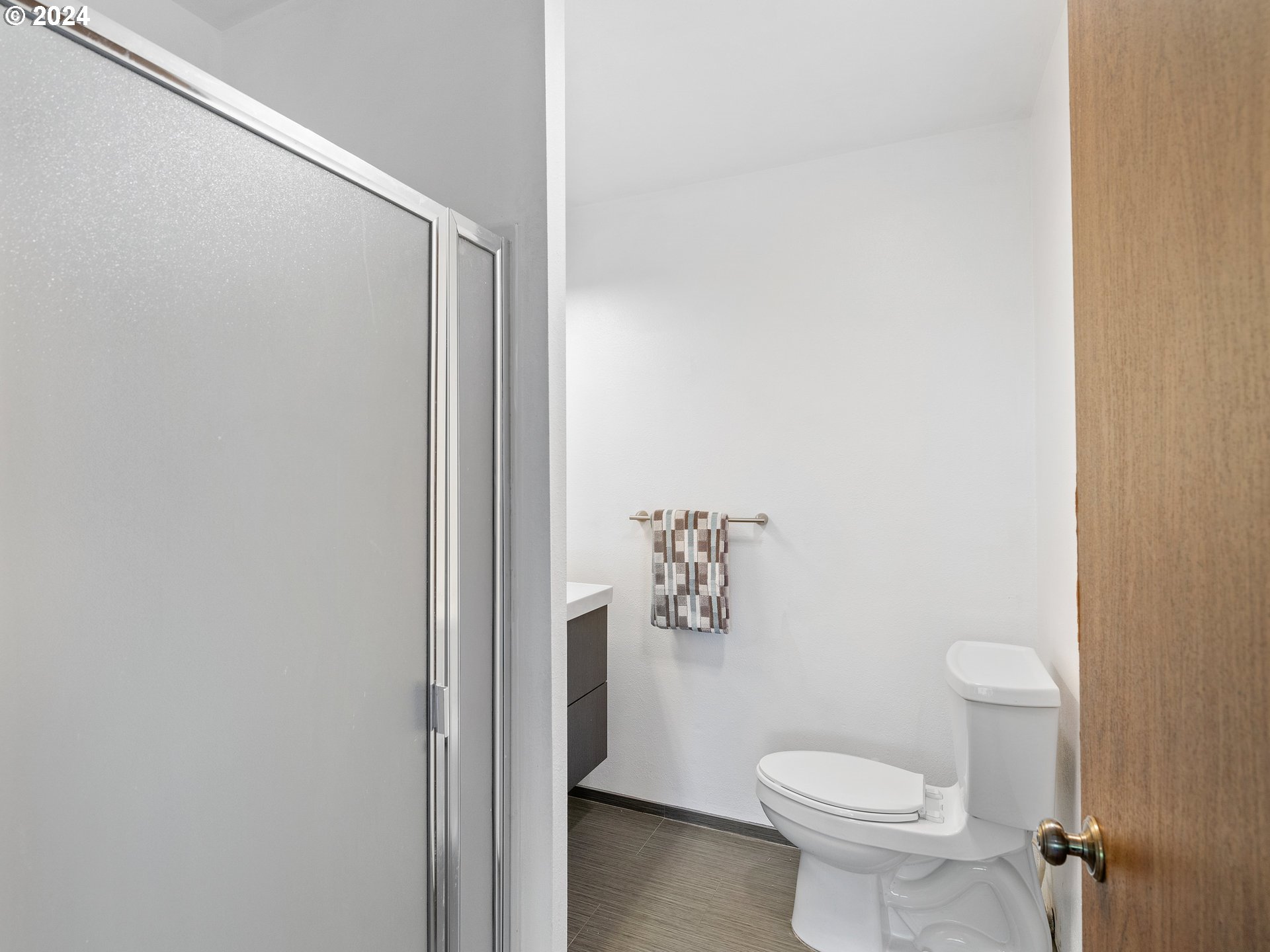 1727 Northeast Multnomah Street, Unit 14 Portland, OR 97232 - Photo 20 of 31 a white toilet sitting next to a shower curtain