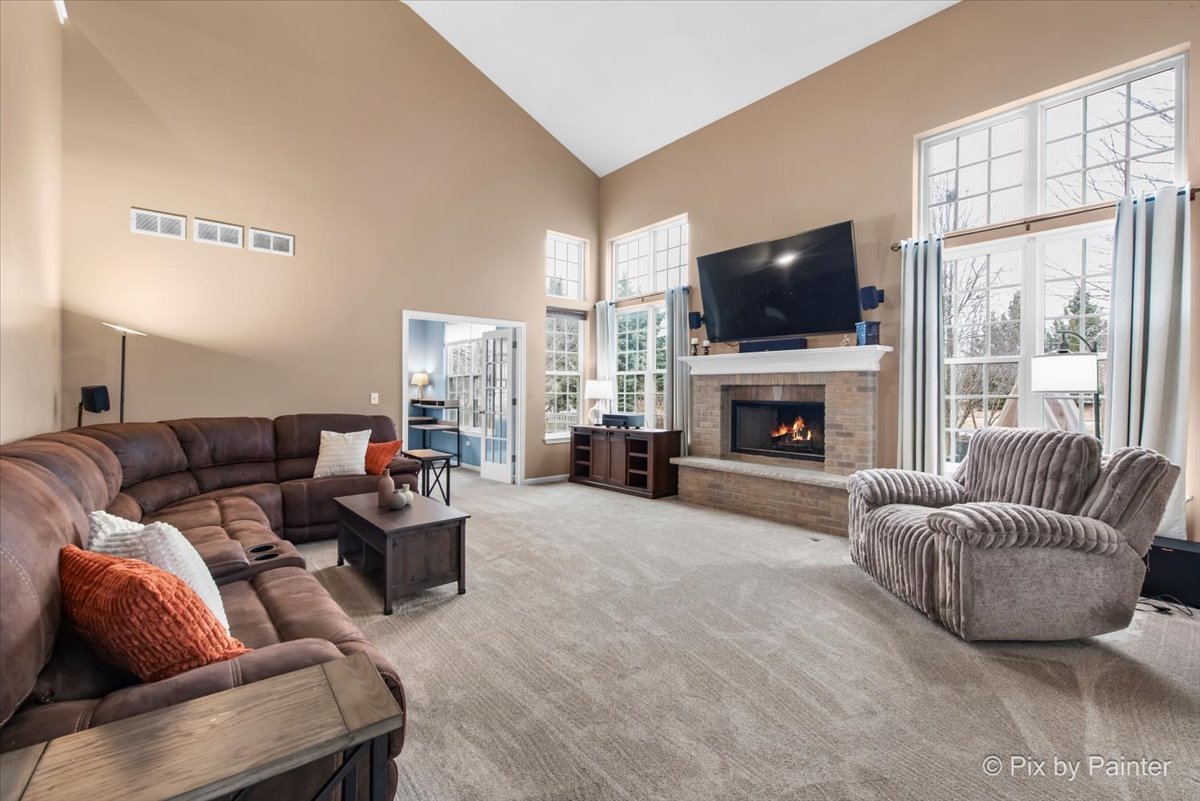 26428 Rustling Birch Way Plainfield, IL 60585 - Photo 12 of 49 a living room with furniture a flat screen tv and a fireplace