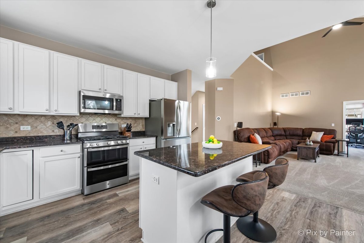 26428 Rustling Birch Way Plainfield, IL 60585 - Photo 6 of 49 a kitchen with sink a counter and chairs