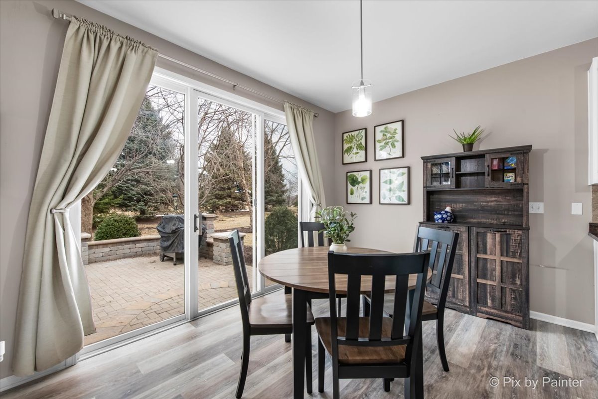 26428 Rustling Birch Way Plainfield, IL 60585 - Photo 7 of 49 a view of a dining room with furniture large windows and wooden floor