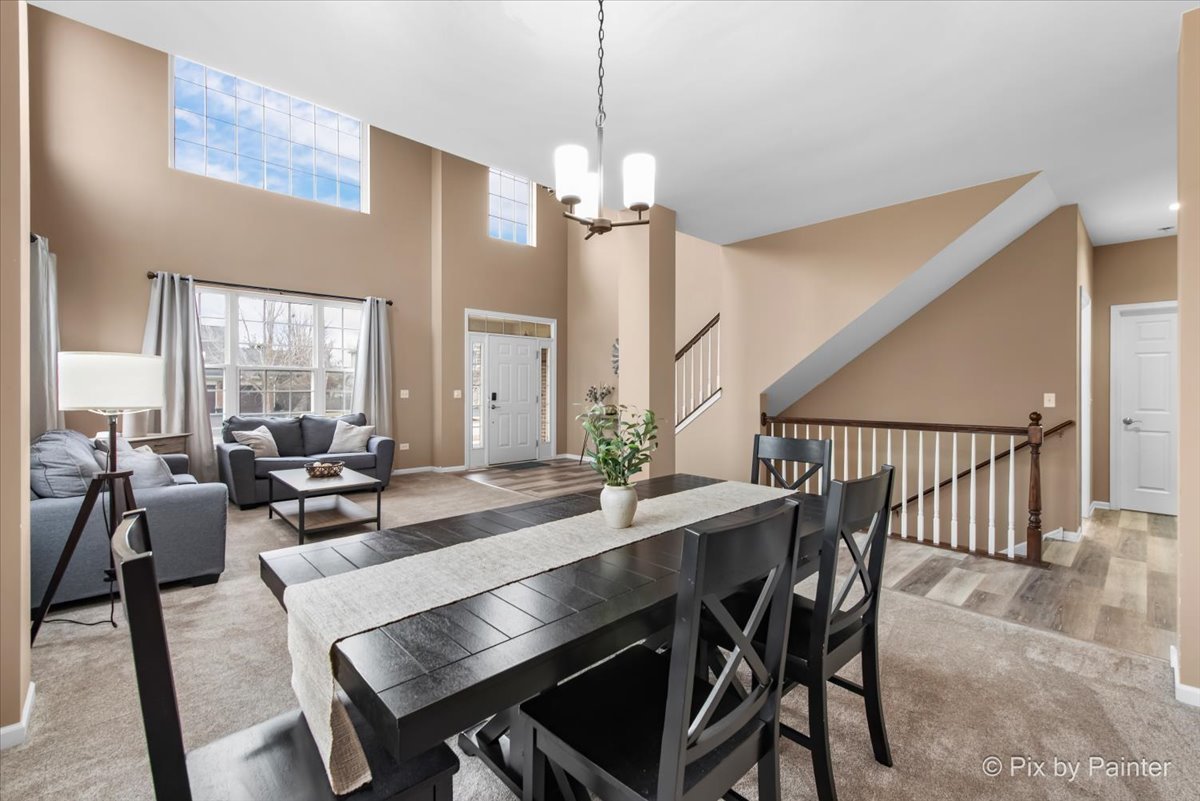 26428 Rustling Birch Way Plainfield, IL 60585 - Photo 10 of 49 a dining room with furniture a chandelier and wooden floor