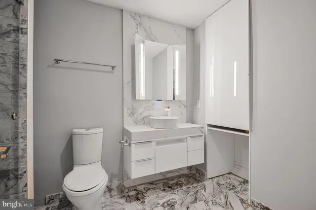 a bathroom with a toilet a sink and mirror