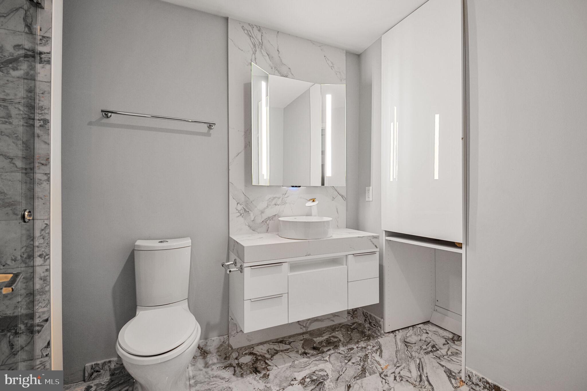 45 Sutton Square Southwest, Unit 607 Washington, DC 20024 - Photo 15 of 28 a bathroom with a toilet a sink and mirror