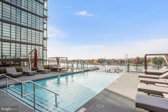 a view of swimming pool with outdoor seating and city view