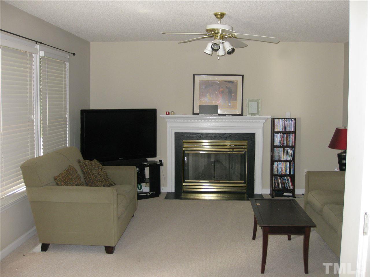 3313 Stone Castle Court Raleigh, NC 27613 - Photo 7 of 15 a living room with furniture a flat screen tv and a fireplace