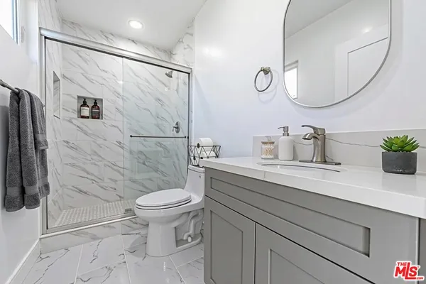 a bathroom with a sink a toilet and shower