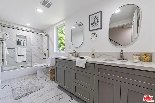 a spacious bathroom with a double vanity sink double mirror and bathtub