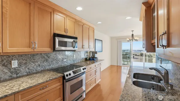 a kitchen with granite countertop a sink and a stove