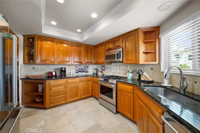 a kitchen with stainless steel appliances granite countertop a refrigerator and a sink