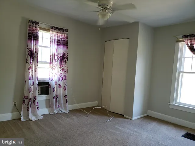 an empty room with windows and closet