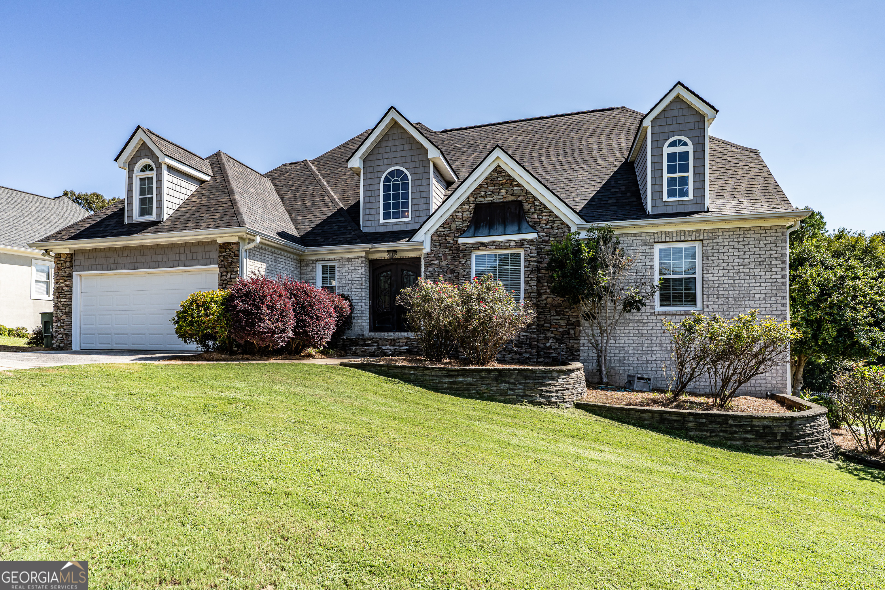 a front view of a house with a garden and plants