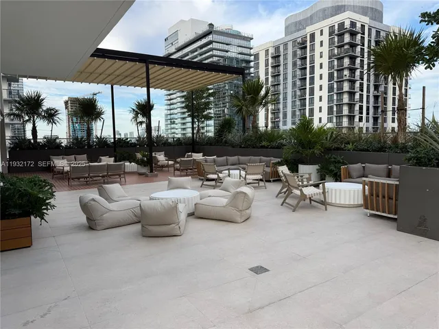 a view of a patio with dining table and chairs under an umbrella