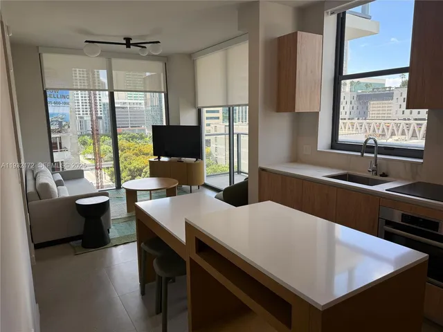 a kitchen with a table chairs a sink dishwasher and a stove