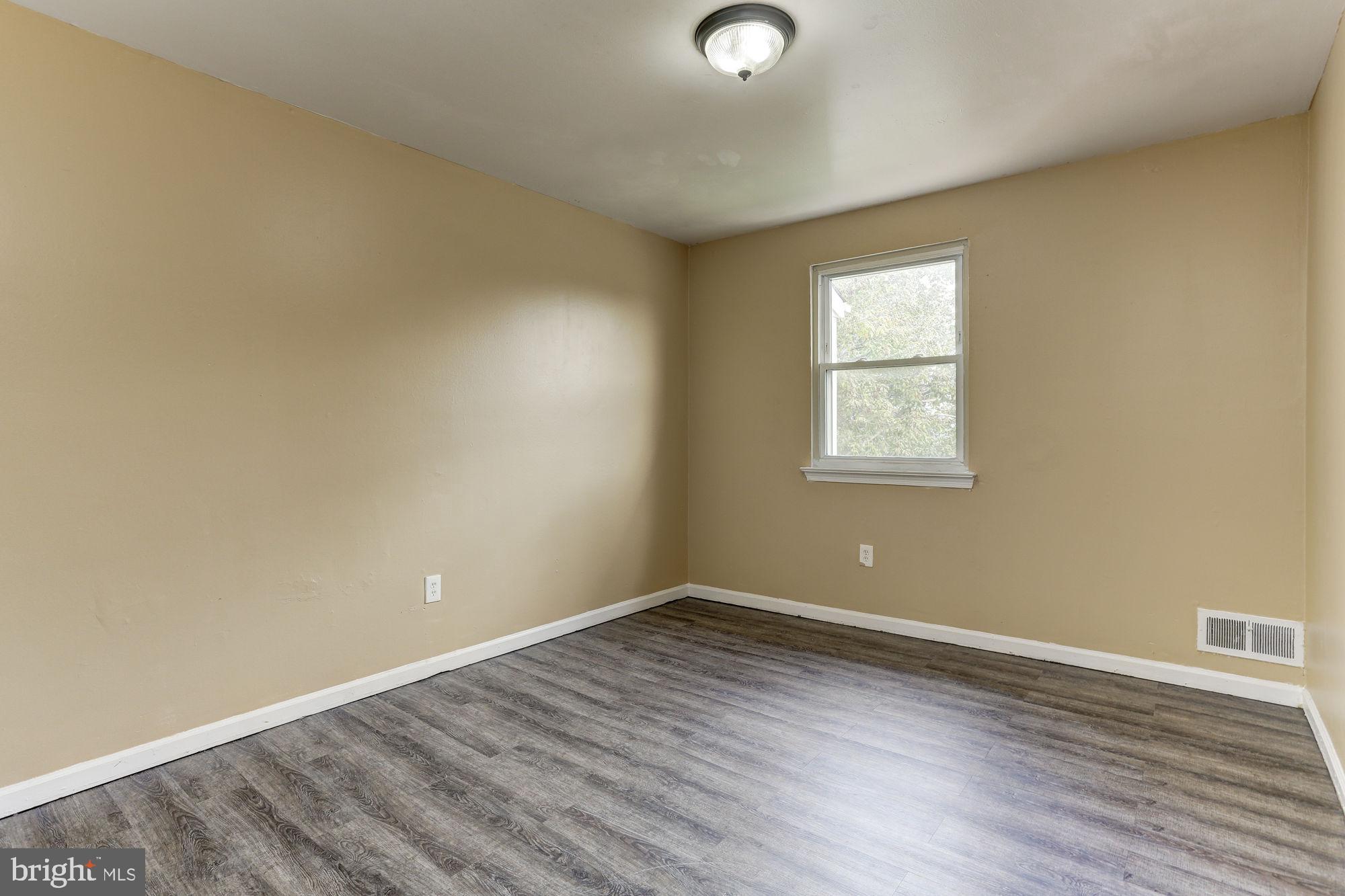 1925 Addison Road South District Heights, MD 20747 - Photo 8 of 9 an empty room with wooden floor and windows