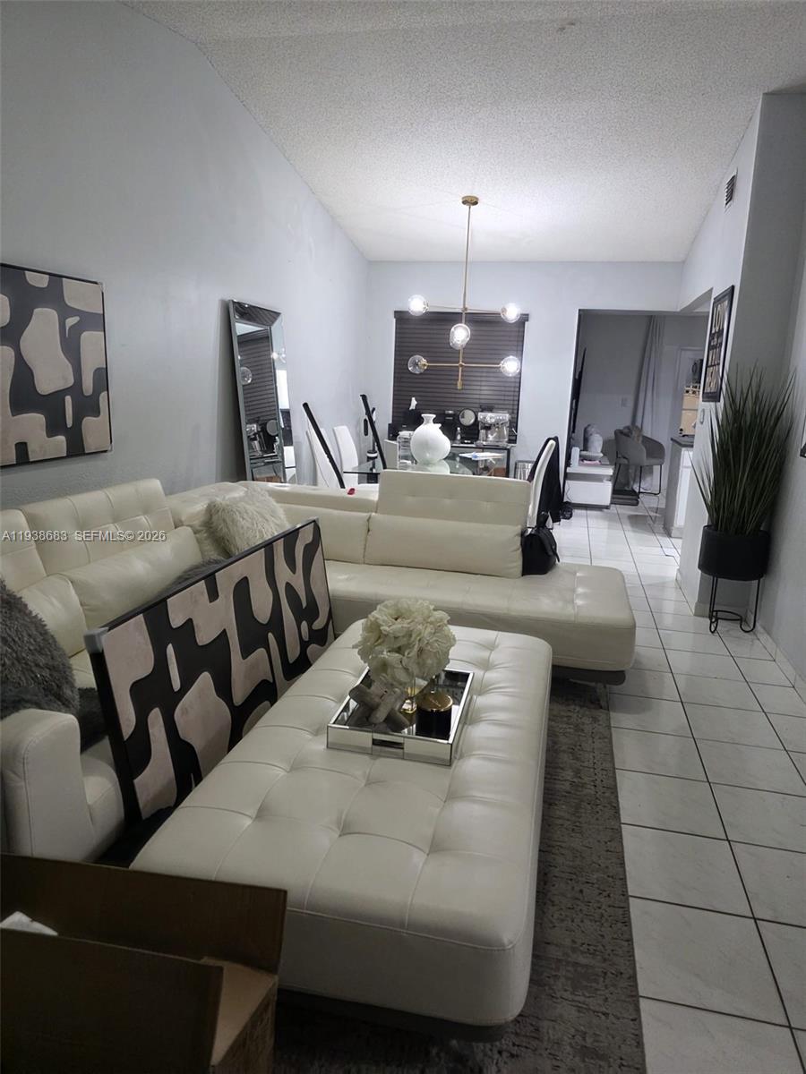 4837 Southwest 144th Court Miami, FL 33175 - Photo 2 of 10 a living room with furniture and a chandelier