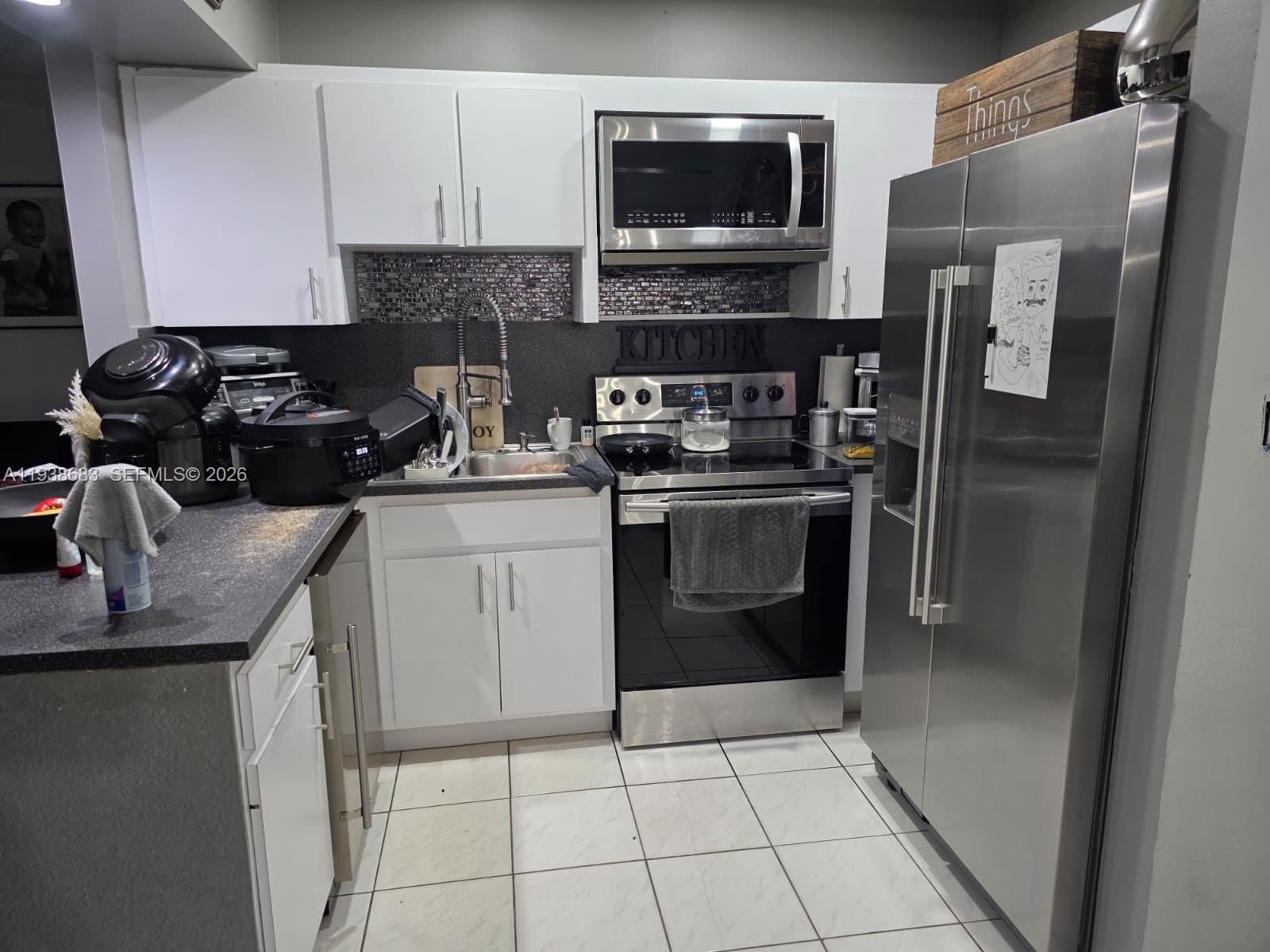 4837 Southwest 144th Court Miami, FL 33175 - Photo 3 of 10 a kitchen with a sink stove and refrigerator