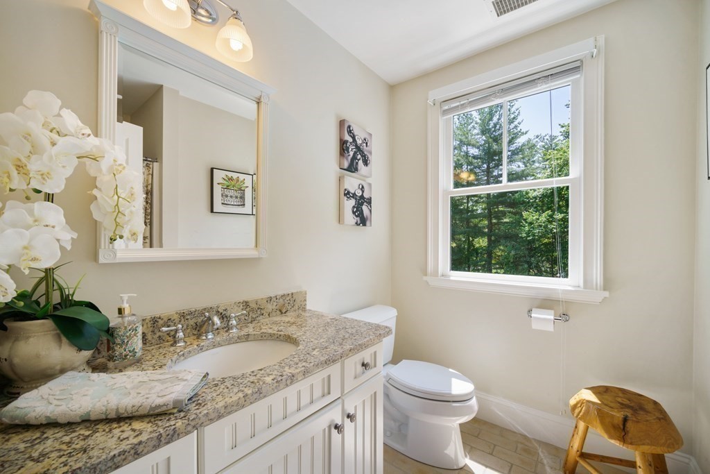 19 Marked Tree Road Sudbury, MA 01776 - Photo 21 of 42 a bathroom with a granite countertop sink mirror vanity and toilet