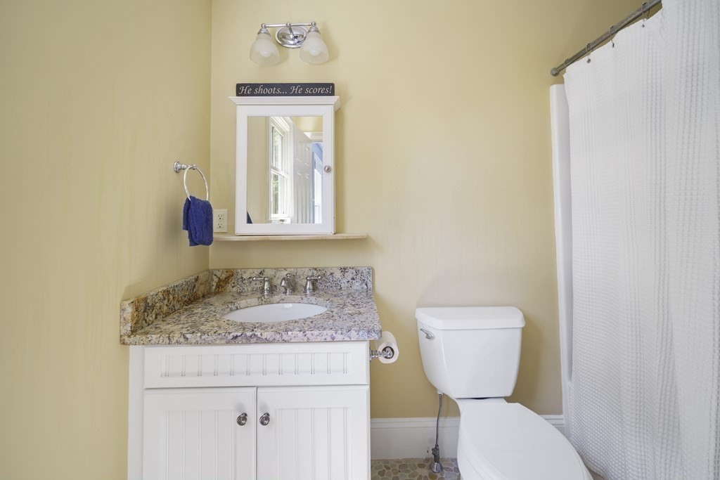 19 Marked Tree Road Sudbury, MA 01776 - Photo 23 of 42 a bathroom with a granite countertop toilet sink and mirror