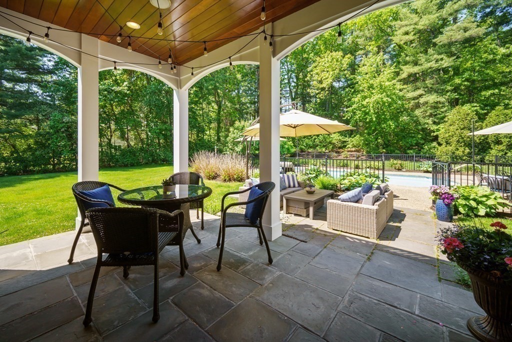 19 Marked Tree Road Sudbury, MA 01776 - Photo 4 of 42 a view of a patio with a dining table and chairs potted plants with swimming pool in the backyard