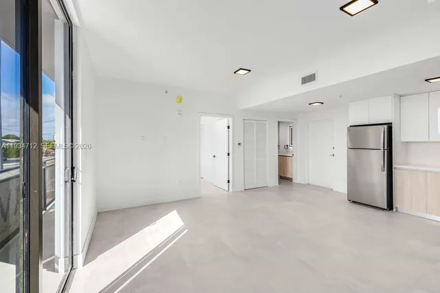 an empty room with floor to ceiling window and closet