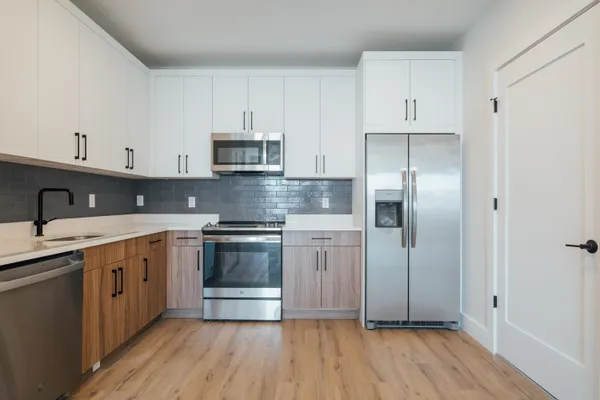 a kitchen with stainless steel appliances granite countertop a stove a sink and a refrigerator