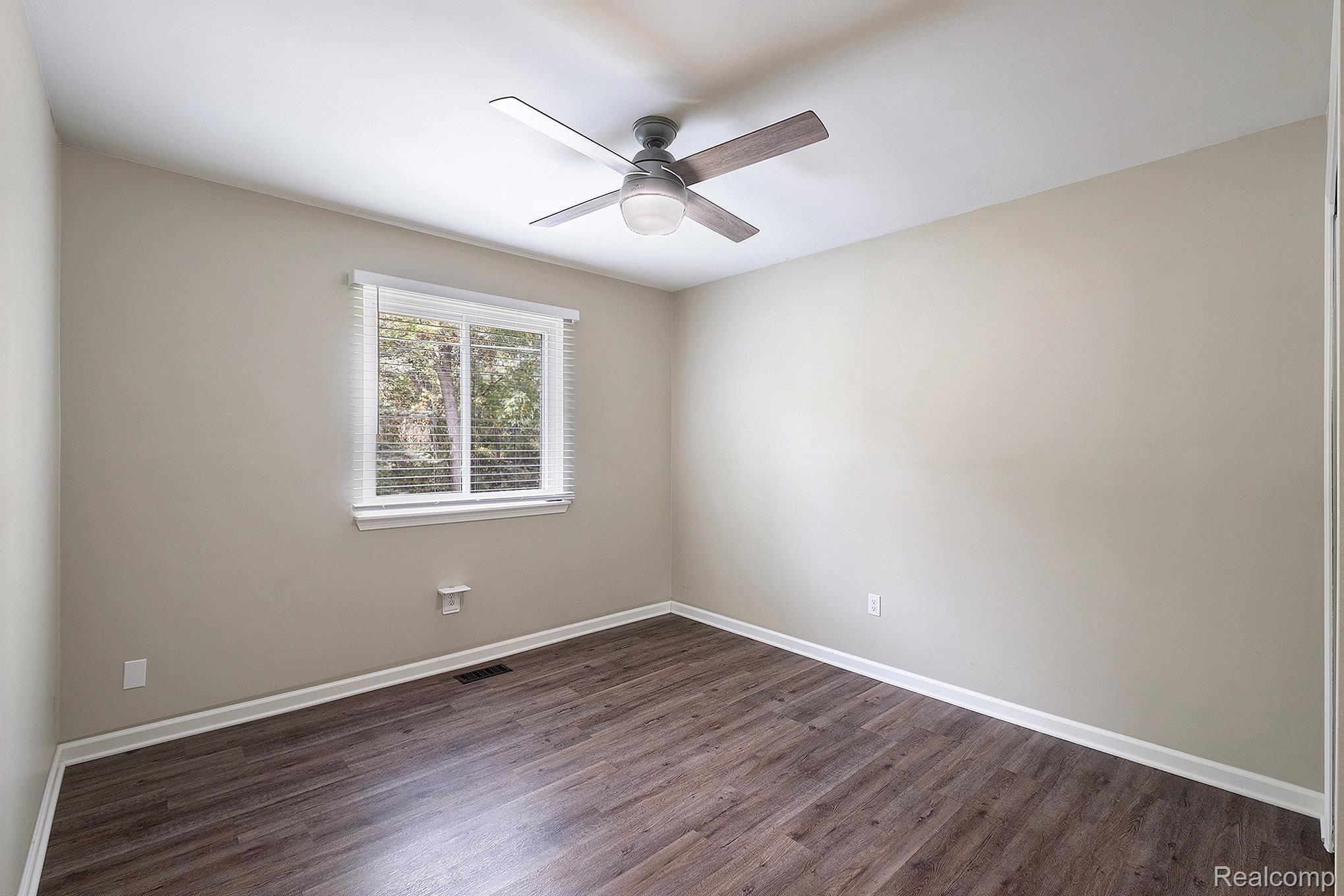 12147 Torrey Road Fenton, MI 48430 - Photo 9 of 19 Empty room with dark wood-type flooring and a ceiling fan