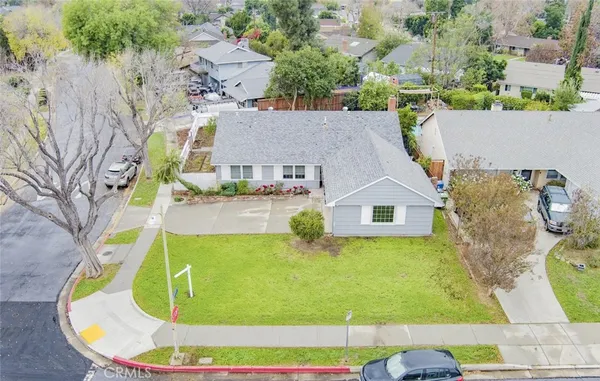an aerial view of a house with swimming pool and large trees