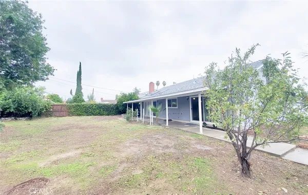 a front view of a house with a yard and trees